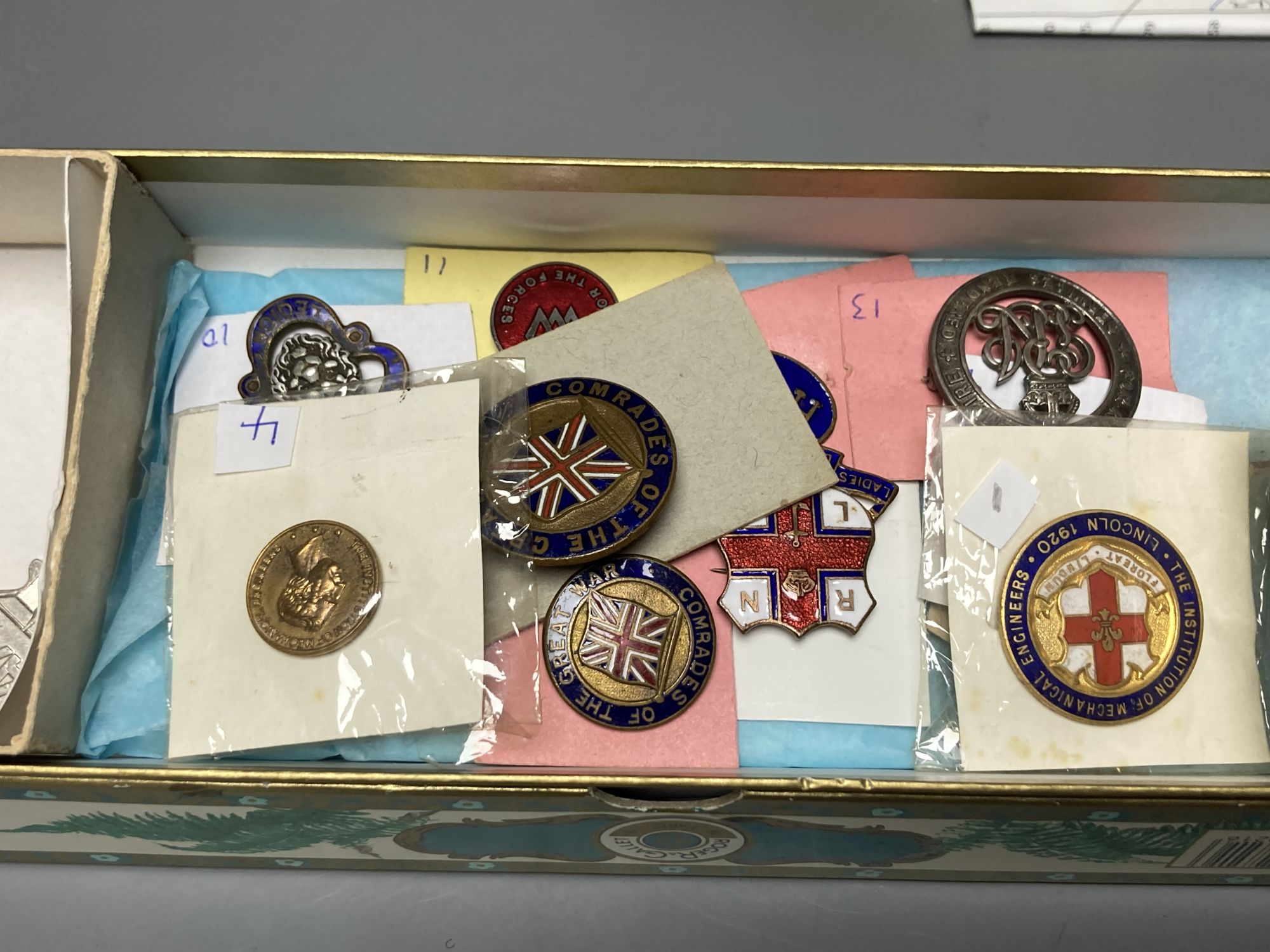 A collection of assorted enamel badges and nursing badges